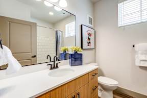 A bathroom with a white counter top and a white toilet.