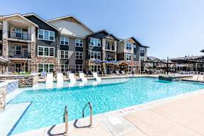 A large swimming pool in front of apartment buildings.