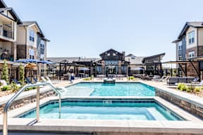 A large swimming pool in front of a resort.
