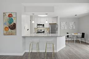 A kitchen with a bar area and a dining table.