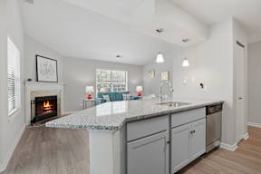 A modern kitchen with a fireplace and a large island.