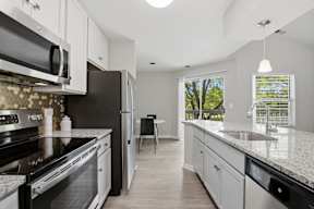 A kitchen with black countertops and white cabinets.