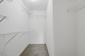 Empty white walk in freezer with shelves.
