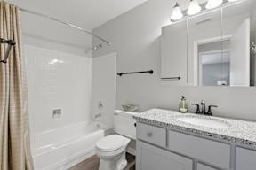 A white bathroom with a toilet, sink, and bathtub.