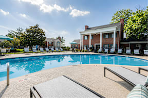 A large outdoor swimming pool with a building in the background.