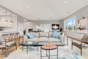 seating area featuring a gray sofa and side chairs in the Eagle Creek Apartments resident lounge