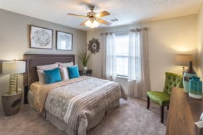 furnished apartment bedroom with carpeting and a ceiling fan