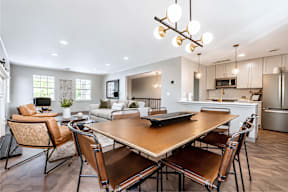 A modern dining room with a wooden table and chairs.