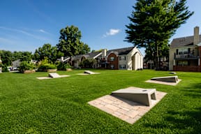 A park with sculptures and houses in the background.