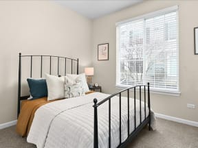 bedroom with a wrought iron bedframe and large window