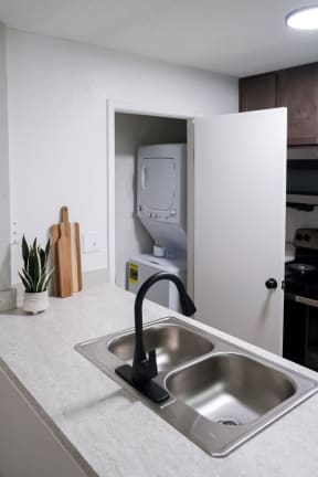 an in-home washer and dryer in a closet off of the kitchen