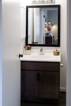 single bathroom vanity under a wall mirror