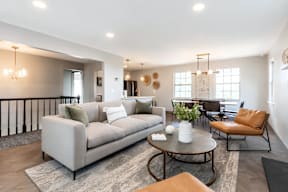 A living room with a grey sofa, a brown armchair, and a coffee table.