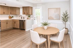 A kitchen with a table and chairs.