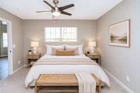 A bedroom with a large bed and a ceiling fan.