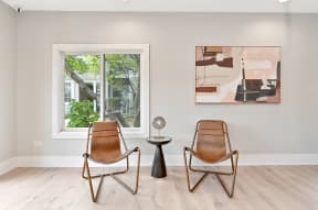 two accent chairs next to a small round side table