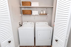 A small bathroom with two toilets and a shelf above them.