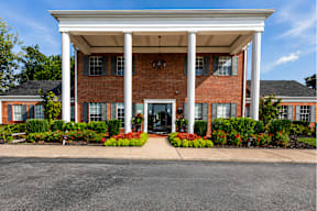 A red brick building with a white roof and pillars.