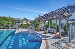 Farmington Lakes community swimming pool surrounded by a pergola with lounge seating