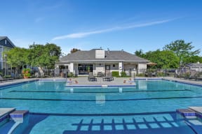 large swimming pool with lap lanes outside the Farmington Lakes Apartments clubhouse