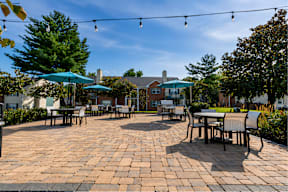 A patio with tables and chairs under umbrellas.