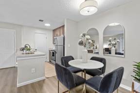 A kitchen with a dining table and chairs.
