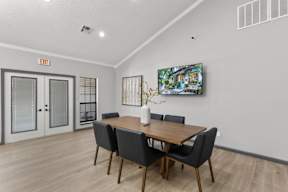 A dining room with a wooden table and chairs.