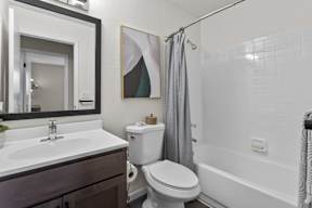 A bathroom with a toilet, sink, and bathtub.