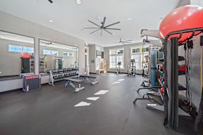 A gym with a variety of equipment including a red exercise ball.