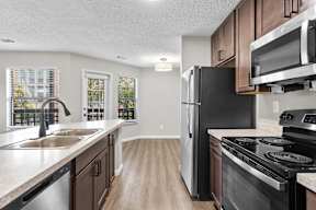 A kitchen with a black refrigerator and stove.