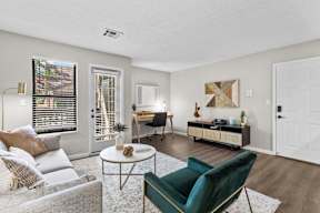 A living room with a grey couch, a green armchair, and a white coffee table.