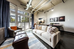 apartment living room with comfortable seating, a dining area, and sliding glass doors at East End Lofts