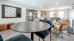 A modern living room with a round table and chairs.