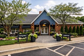 A blue building with a sign that says Leasing Office and Clubhouse.