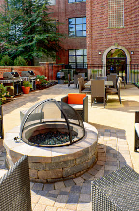a courtyard with a fire pit and tables and chairs