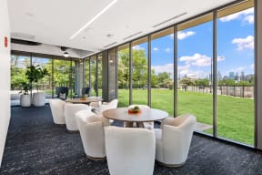 plush white chairs around tables next to floor to ceiling windows