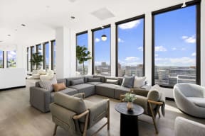 large gray sectional and side chairs in a room with floor-to-ceiling windows