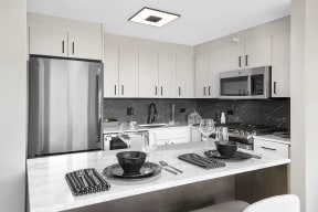 modern kitchen with white quartz countertops and stainless steel appliances