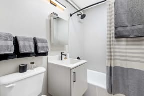 bathroom with a single vanity and tub shower combo