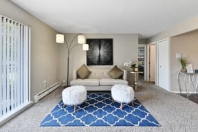 a living room with a white couch and blue rug