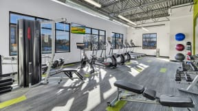 a workout room with cardio equipment and windows