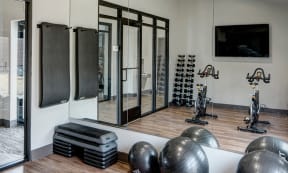 Willow Crossing Apartments resident fitness center with exercise equipment and mirrors on the wall
