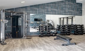 Willow Crossing Apartments fitness center with free weight racks and a multi-station weight machine