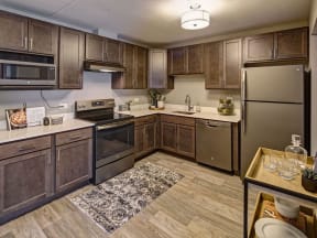 apartment kitchen with stainless steel appliances and wooden cabinets
