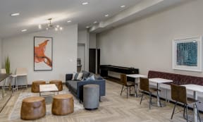 Willow Crossing Apartments clubhouse with a lounge area, dining section, and shuffleboard table