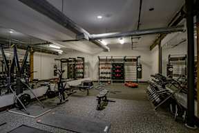 A gym with a variety of equipment including weights and weight machines.