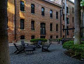 A courtyard with a table and chairs surrounded by brick buildings.