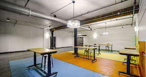 A room with tables and chairs and a blue floor.