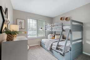 an attic bedroom with bunk beds and a dresser and window