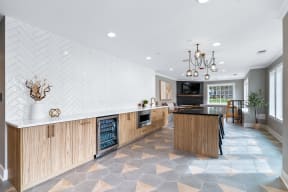 the kitchen has a large island with a marble counter top and wooden cabinets